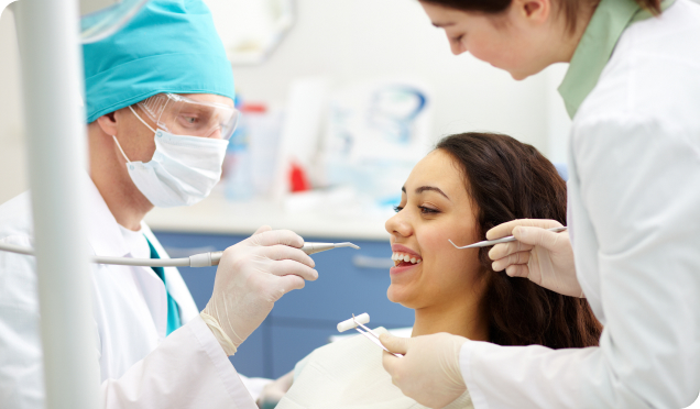 Two dental experts performing cosmetic dental treatment on a woman - Living Water Dentistry offers a wide range of cosmetic dental treatments in Surrey, BC