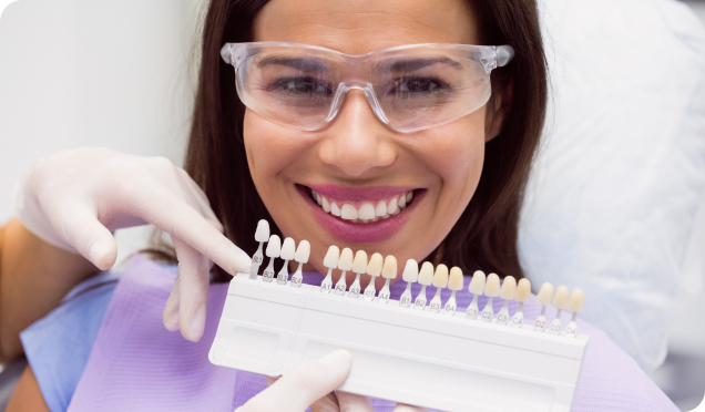 Dental Expert Comparing The Color Match Of Multiple Prosthetic Teeth Stock With A Patient's Natural Teeth For Dental Implants Treatment
