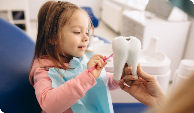 Child holding oversized dummy tooth and toothbrush, illustrating dental care - Living Water Dentistry offers specialized pediatric dental treatment
