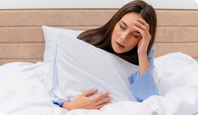 Exhausted Woman In Bed Holding A Pillow, Unable To Sleep Due To Sleep Apnea | Living Water Dentistry - Surrey Sleep Clinic