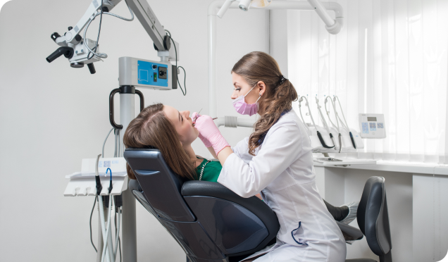 A woman comfortably undergoing root canal treatment while sitting in a dental treatment chair under the care of a dentist.