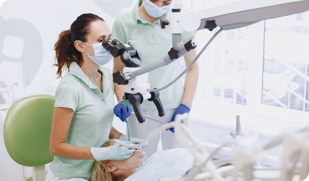 Dentist carefully examines and performs efficient root canal treatment using a dental microscope.