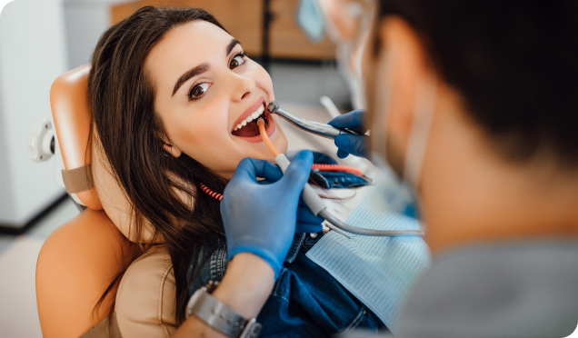 Dental Expert Performing Teeth Cleaning Treatment To A Woman. Living Water Dentistry In Surrey, BC